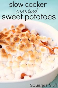 a bowl filled with marshmallows on top of a blue table next to a spoon