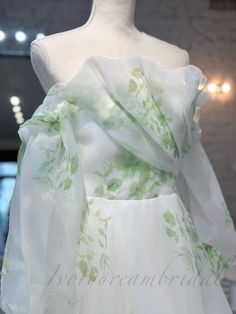 a white dress with green leaves on it