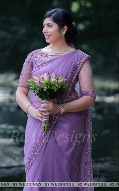 a woman in a purple sari holding flowers