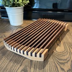 a close up of a wooden slatted surface on a table next to a potted plant