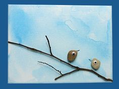 two birds sitting on top of a tree branch with eyes painted on it's branches