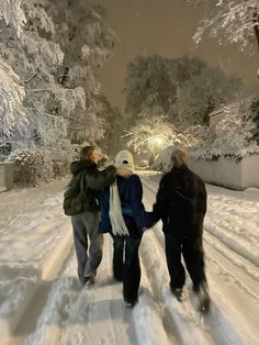 three people walking in the snow holding hands