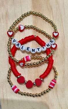 three bracelets with beads and charms that say, valentine's day on them