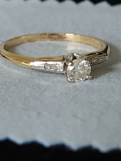 a diamond ring sitting on top of a white cloth