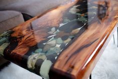 the table is made out of wood and has pebbles on it, as well as glass