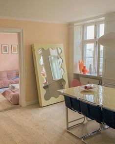 a living room filled with furniture and a large mirror on top of a wooden floor