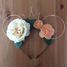 a mickey ears headband with flowers on the top and two leaves attached to it