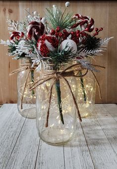 two mason jars filled with flowers and greenery