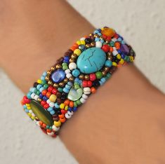 COLOR MANIA. WOW! These amazing color combinations will lift up any outfit. The wild combination of shell, stones, turquoise and beads is really special. All elements intricately woven into a 1 cm wide macramé flexible cuff it is effortless to put on and remove. And this bracelet is super comfy and fits like a glove. You will definitely get a lot of comments on these beauties - and it looks fabulous with your LBD (little black dress). The vibrant colors really pop! The diameter is about 5cm and at the irresistible price of only $US38 you can pick up a few. Each one is a unique work-of-art. It would make a fabulous gift for that special someone who likes bright pieces. And it comes with a complementary felt gift bag. FREE SHIPPING TO ABSOLUTELY ANYWHERE Thanks for visiting ARTMANIA Traditional Multicolor Beaded Bracelets With Natural Stones, Traditional Multicolor Natural Stone Beaded Bracelets, Artisan Multicolor Beaded Bracelets For Beach, Bohemian Turquoise Beaded Braided Bracelets, Bohemian Beaded Cuff Bracelet For Beach, Bohemian Turquoise Braided Beaded Bracelets, Adjustable Beaded Cuff Bracelet For Beach, Artisan Multicolor Beaded Bracelets With Natural Stones, Artisan Multicolor Beaded Bracelet With Natural Stones