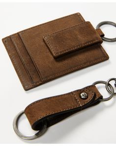 a brown leather wallet and keychain on a white surface with a metal ring