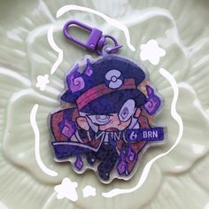 a close up of a keychain with a cartoon character on the front and back