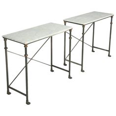 two tables with metal legs and white marble top, one is turned upside down to the side