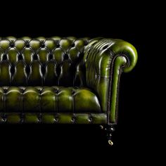 a green leather couch on a black background