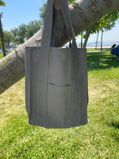 a gray bag hanging from a tree branch