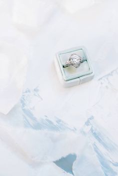 an engagement ring sitting in a box on a white surface