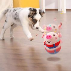 a small dog playing with a toy on the floor in front of a stuffed pig