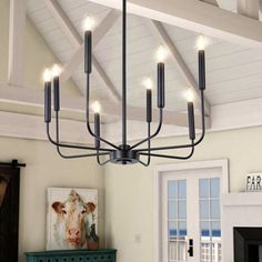 a chandelier hanging from the ceiling in a living room with white walls and furniture