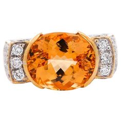 GIA certified vintage geometric Natural Orange Topaz and Diamond Ring, set in 18K Yellow Gold. This lovely cocktail ring boasts a brilliant oval-cut orange topaz center stone in half bezel setting, and round-cut diamond side stones. This ring is made with 18K yellow gold, and presented with a squared geometric shape. The center stone bears a rich, canary orange color hue with excellent luster and transparency. Item Details: - Type: Cocktail Ring - Metal: 18K Yellow Gold - Weight: 19.05 Grams - Ring Size: 8 (adjustable) - Setting: Half Bezel, Prong ___________________________________ Center Stone Details: - Type: Topaz - Carat: 7.30 (approx.) - Cut: Oval (Modified Brilliant) - Color: Orange-Yellow - Transparency: Transparent - Measurements: 13.13 x 11.02 x 7.45 mm GIA Certificate #: 5234030 Topaz And Diamond Ring, Half Bezel Setting, Cut Orange, Half Bezel, Gia Certificate, Diamond Ring Set, Ring Metal, Bezel Diamond, Vintage Ring