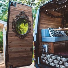 the interior of a camper van with its doors open and bed in the back