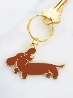 a keychain with a dachshund on it sitting on a marble surface