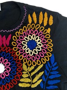 Beautifully hand embroidered shirts made in Mexico by our artisan partners who are expert embroiderers. Each shirt will come in the color you pick with the embroidery slightly varying in colors. This shirt will be a staple in your wardrobe / store!Runs SMALL. Order 1-2 sizes larger. Large & XL are the best sellers. Traditional Embroidered Cotton T-shirt, Traditional Cotton Tops With Tonal Embroidery, Black Cotton Top With Geometric Embroidery, Traditional Short Sleeve Embroidered Top With Tonal Embroidery, Traditional Cotton T-shirt With Multicolor Embroidery, Traditional Short Sleeve Tops With Tonal Embroidery, Traditional Multicolor Embroidery Cotton T-shirt, Geometric Embroidery Crew Neck Cotton Tops, Traditional Multicolor Embroidered Cotton T-shirt