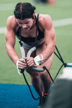 a woman is doing exercises on the ground with her hands and legs bent over an iron