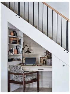 a desk with a laptop on it under a stair case in a home office area