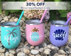 three personalized tumblers with straws are sitting on the rocks next to some flowers