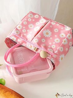 a pink lunch box sitting on top of a table