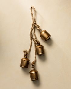 three bells hanging from a rope on a wall