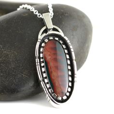 A beautiful Idaho Sunset Jasper Agate stone set in a Sterling Silver Necklace. This stunning jasper agate is a new and rare material mined in central Idaho with the most amazing color patterns. This stone loves being in the sunlight where the colors really pop and stand out the best. The colors can appear darker in shadier conditions. Pendant measures 2.5cm wide by 6.4cm long. Comes on an 18 inch sterling silver oval belcher chain. Includes gift box. Handmade by Annie Summers. We are husband and Artisan Jasper Jewelry Gift, Elegant Jasper Necklace For Gift, Unique Jasper Jewelry Gift, Unique Jasper Jewelry For Gifts, Jasper Jewelry For Gifts, Handmade Jasper Oval Necklaces, Handmade Oval Jasper Necklaces, Handmade Jasper Oval Necklace, Jasper Gemstone Jewelry As Gift