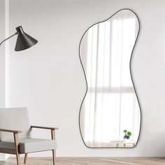 a living room with a chair and a large mirror on the wall next to a window