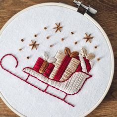 a close up of a embroidery on a hoop with a small piece of fabric in the shape of a sleigh