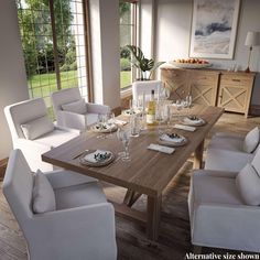 a dining room table set with white chairs and place settings for six people, in front of large windows