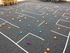 an indoor play area with balls on the floor and children's chairs in the background