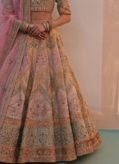 Features a gold organza double dupatta lehenga set embroidered with traditional zardozi technique using silken threads, dabka, cutdana and sequins highlighted with multiple pastel hued velvet appliques. Completed with two dupattas in rust gold and pink for your big day. Composition : Lehenga, Blouse and Dupatta- Organza, Velvet Care: Dry Clean Only and Vacuum Storage This product can be customised for sleeves, length of blouse and neckline Delivery : 6-8 weeks as the product is hand crafted. Check Size Guide or choose MySize for free customisation (All Sizes above XL can be made at 15% additional cost) For more information and sizes please contact fabiliciousfashion@gmail.com or visit our Copenhagen studio.About the Designer : Angad Singh's journey in the world of fashion started with at a Gold Semi-stitched Gown With Dori Work, Traditional Gown With Intricate Embroidery In Dola Silk, Traditional Dola Silk Gown With Intricate Embroidery, Traditional Dola Silk Gown With Dupatta, Traditional Eid Gown With Dori Work, Traditional Semi-stitched Gown With Pallu, Traditional Dola Silk Gown With Zari Work, Traditional Festive Gown In Dola Silk, Traditional Festive Dola Silk Gown