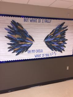 a bulletin board with two blue feathers on it's sides and the words but what if i fall?