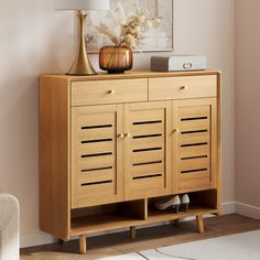 a wooden cabinet with two drawers and a lamp on top of it in a living room