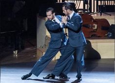 two men in suits are dancing on stage