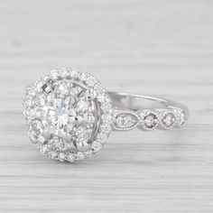 a white gold engagement ring with an oval center surrounded by small round brilliant cut diamonds