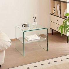 a glass table with a book on it in a living room next to a couch