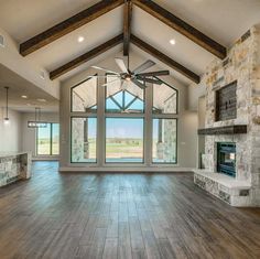 an empty living room with large windows and wood flooring is pictured in this image