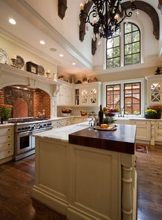 a large kitchen with an island in the middle and lots of windows on both sides