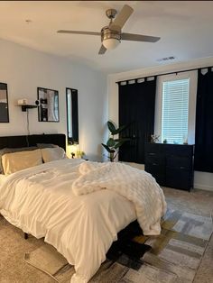 a bedroom with a bed, dresser and ceiling fan in the middle of the room