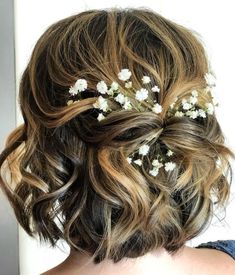 the back of a woman's head with flowers in her hair