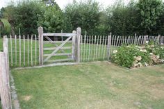 a wooden gate in the middle of a grassy yard