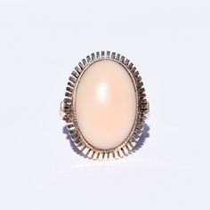 A charming angel skin coral ring in 8k gold. Features a large pink cabochon mounted in a bezel setting with a stylized cutout trim. The design is simple yet striking, and the ring would make a fabulous addition to an estate jewelry collection. The gold has an antique patina with some surface scuffs, and the cabochon remains secure in its setting. The inner band is hallmarked '8K', and the gold has been tested for authenticity. In good vintage condition with age-appropriate wear and discoloration.  **This listing contains photographs of the actual item you will receive. Please look closely at the pictures, which are part of the product description. Every piece is cleaned, polished, examined, and described to the best of our ability, and we encourage you to reach out with any questions.** Co Angel Skin, Brooch Men, Coral Ring, Native Jewelry, Luxury Rings, Ring Pendant Necklace, Rings Cool, Pink Ring, Cocktail Ring