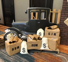 an old model t car is sitting on the floor with bags of money in front of it