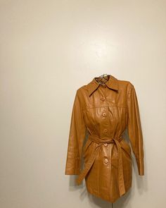 "Early 60s/70s Wilson's leather jacket Tie belt at waist, mod style lines across jacket. Pockets at hips. Buttons up front. Fully lined and in great condition with minimal markings. Labeled size 12, fits like a modern women's small, see measurements which were taken lying flat: 33\" chest 34\" long 24\" sleeves" Retro Long Sleeve Leather Jacket For Work, Retro Fitted Leather Jacket For Fall, Retro Belted Fall Outerwear, Retro Leather Jacket For Spring, Fitted Retro Leather Jacket For Fall, Retro Belted Outerwear For Fall, Spring Retro Leather Jacket, Retro Leather Jacket For Winter Workwear, Retro Leather Jacket For Fall