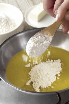 a wooden spoon in a pan filled with food